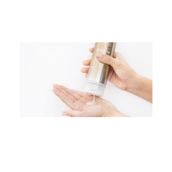 A person holding onto a bottle of lotion