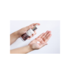 A person holding onto a bottle of lotion