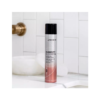 A bottle of hair spray sitting on top of a counter.