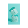 Two jars of body cream on a blue background