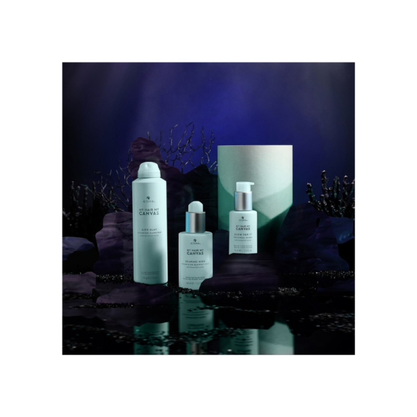A group of three bottles sitting on top of rocks.