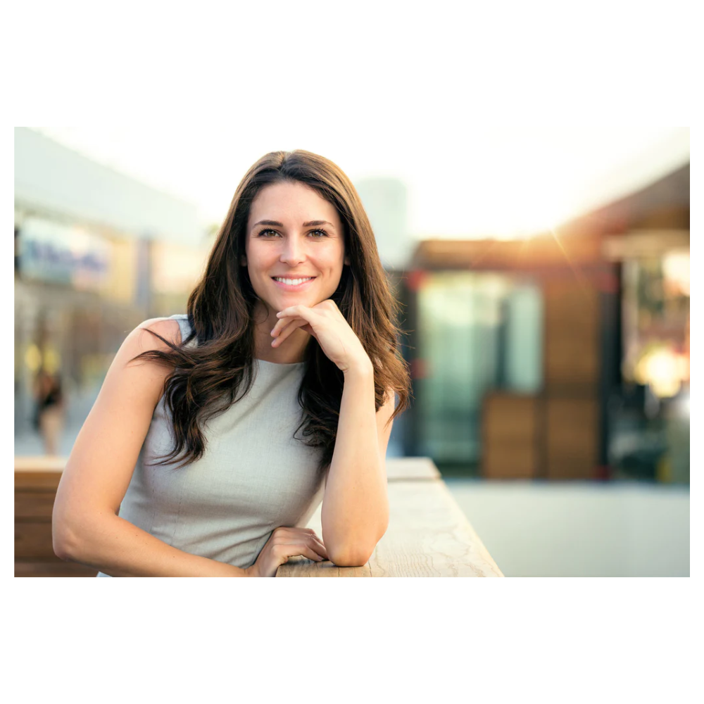 A woman sitting on top of a bench in front of a building.